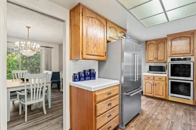 a kitchen with wooden cabinets and a dining room at Home in San Diego! The Blue Leaf with 3bed 2bath, Golf, Large Yard! in Rancho Bernardo