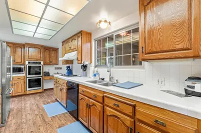 a kitchen with wooden cabinets and white counter tops at Home in San Diego! The Blue Leaf with 3bed 2bath, Golf, Large Yard! in Rancho Bernardo