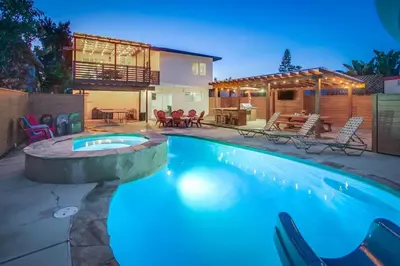 a swimming pool with a patio and a house at 4BR Retreat - Pool Bar Play Area - Walk to Beach in Oceanside
