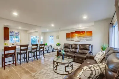 a living room with a couch and a table at 4BR Retreat - Pool Bar Play Area - Walk to Beach in Oceanside