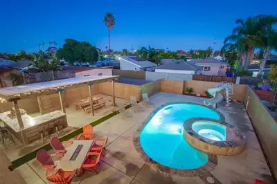 an overhead view of a swimming pool with a table and chairs at 4BR Retreat - Pool Bar Play Area - Walk to Beach in Oceanside