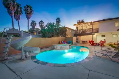 a small swimming pool with a slide in a backyard at 4BR Retreat - Pool Bar Play Area - Walk to Beach in Oceanside
