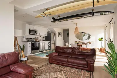 a living room with a leather couch and a kitchen at La Jolla Private Beach Oceanfront in San Diego