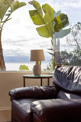 a living room with a leather couch and a table with a lamp at La Jolla Private Beach Oceanfront in San Diego