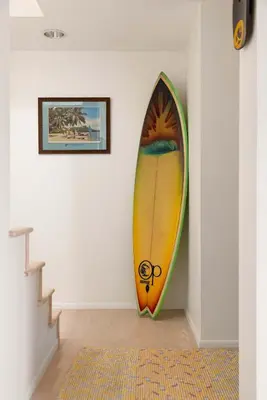a surfboard leaning against a wall next to a staircase at La Jolla Private Beach Oceanfront in San Diego