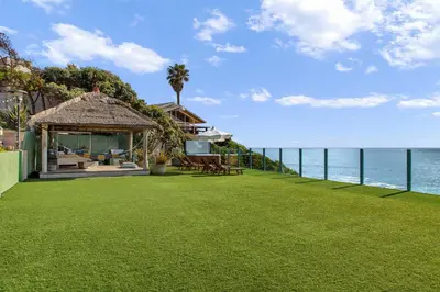 a lawn with a gazebo next to the ocean at La Jolla Private Beach Oceanfront in San Diego