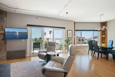 a living room with a television and a dining room at Pacific Beach Rooftop Views in San Diego
