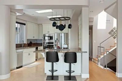 a kitchen with a counter and two stools at Pacific Beach Rooftop Views in San Diego