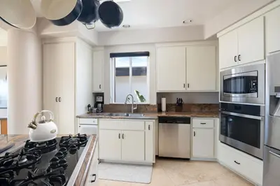 a kitchen with white cabinets and a stove top oven at Pacific Beach Rooftop Views in San Diego