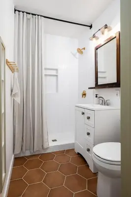 a bathroom with a toilet and a sink and a mirror at Carlsbad Cottage - Remodeled in Carlsbad