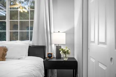 a bedroom with a bed and a table with a lamp at Sprawling Escondido Estate Garden Pool Games ADU's in Escondido