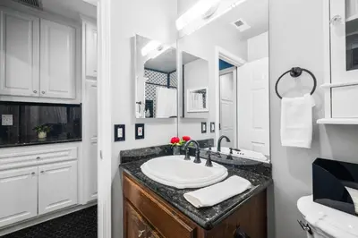 a white bathroom with a sink and a mirror at Sprawling Escondido Estate Garden Pool Games ADU's in Escondido