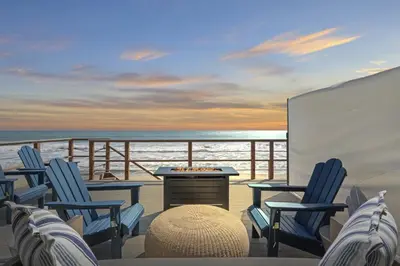 a balcony with chairs and a table on a ship at Private beach toes on the Sand Waterworld in Dana Point