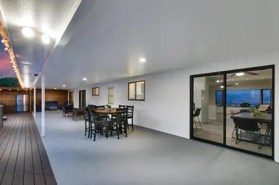 a dining room with tables and chairs and windows at Sleeps 31 10br Mountain View, Pool, Spa and Games in El Cajon