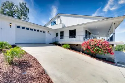 a white house with a driveway at Sleeps 31 10br Mountain View, Pool, Spa and Games in El Cajon