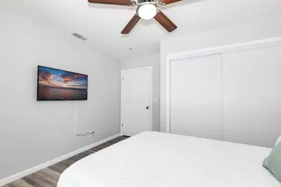 a white bedroom with a ceiling fan and a bed at Mountain View 6BR Pool, Spa and Games Room in El Cajon