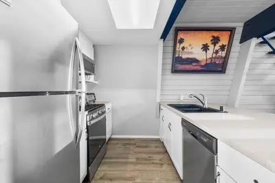 a kitchen with a refrigerator and a sink at The SeaBarn Vista Views, Hot Tub and Stargazing in San Diego