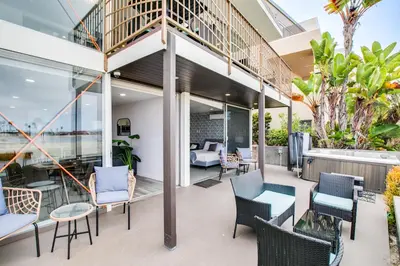 a balcony of a house with chairs and tables at Boardwalk Studio Shared Hot Tub and Patio in San Diego