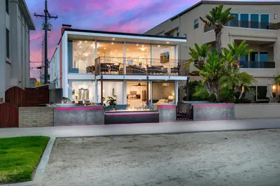 a house with a large glass facade at dusk at Bayfront Beauty 3BR Mission Bay Retreat in San Diego