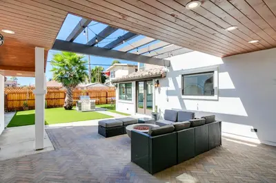 a patio with a couch and chairs on a house at Luxury Oasis with Ping Pong, Firepit and Cozy Patio in San Clemente
