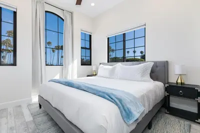 a bedroom with a large white bed with windows at Inviting 3BR Space with Firepit in San Clemente