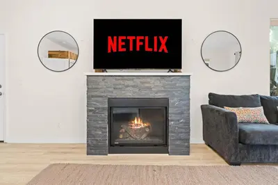 a living room with a fireplace with a television on top at Modern La Jolla Escape Pool Rooftop Views in San Diego
