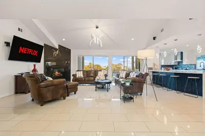 a large living room with leather furniture and a kitchen at Modern La Jolla Escape Pool Rooftop Views in San Diego