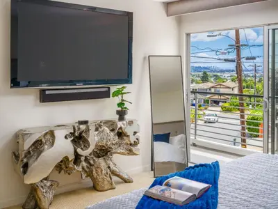 a bedroom with a large flat screen tv on the wall at Luxury Resort Pool, Spa, Swim Up Bar and Bay Views in San Diego