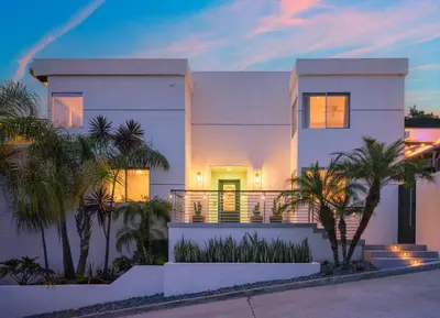 a white house with palm trees in front of it at Luxury Resort Pool, Spa, Swim Up Bar and Bay Views in San Diego