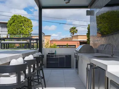 an outdoor kitchen with bar stools and a balcony at Luxury Resort Pool, Spa, Swim Up Bar and Bay Views in San Diego