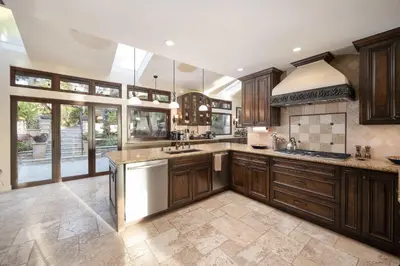 a large kitchen with wooden cabinets and stainless steel appliances at Oceanfront Luxury Home Sunset Views in San Diego
