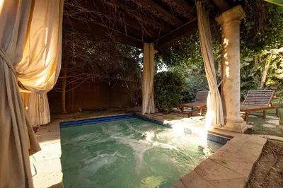 a swimming pool under a gazebo with two chairs at Oceanfront Luxury Home Sunset Views in San Diego