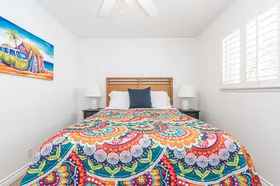 a bedroom with a large bed with a colorful bedspread at 3Br Coastal Home W Large Oceanview Patio, Steps To Sand By Beachview Rentals in Newport Beach
