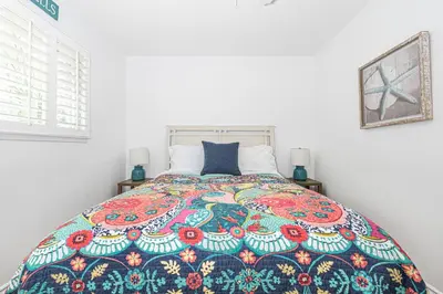 a bedroom with a bed with a colorful quilt on it at 3Br Coastal Home W Large Oceanview Patio, Steps To Sand By Beachview Rentals in Newport Beach