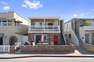 a house with a red door and a balcony at 4Br Coastal Home W Oceanview Patio, Close To The Beach By Beachview Rentals in Newport Beach