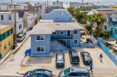 a blue house with cars parked in a parking lot at #759 PetFriendly Beachside retreat/laundry&Parking in San Diego