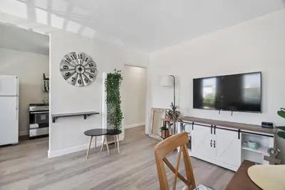 a living room with a table and a tv on a wall at #759 PetFriendly Beachside retreat/laundry&Parking in San Diego