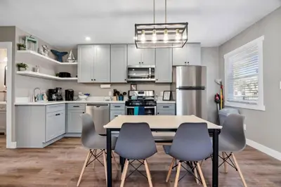 a kitchen with white cabinets and a table and chairs at #763 Steps from the Sand -2b2b Laundry Parking AC in San Diego