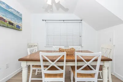 a dining room with a wooden table and chairs at 3Br Oceanview Corner Retreat One House From The Beach By Beachview Rentals in Newport Beach
