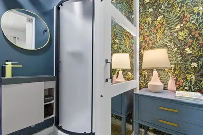 a bathroom with a mirror and a blue wall at Sunnyside Resort Spa, Beach, Zoo, Arcade in La Mesa