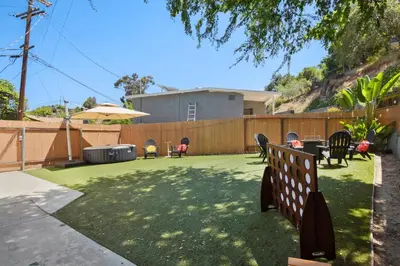 a yard with chairs and an umbrella and a fence at Sunnyside Resort Spa, Beach, Zoo, Arcade in La Mesa