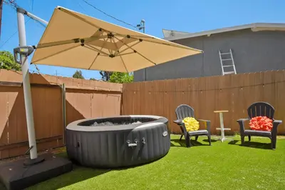 a patio with an umbrella and two chairs and a table at Sunnyside Resort Spa, Beach, Zoo, Arcade in La Mesa