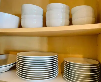 a stack of plates and bowls on a shelf at Sunnyside Resort Spa, Beach, Zoo, Arcade in La Mesa