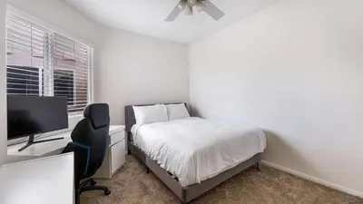 a bedroom with a bed and a desk with a computer at Walk to Dining Mission Pacific Beach and BarsNightlife Private Backyard in San Diego