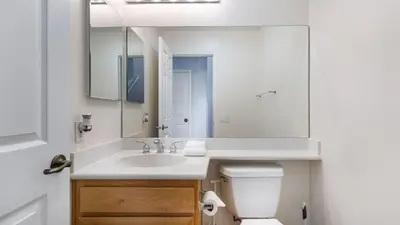 a bathroom with a sink and a toilet and a mirror at Walk to Dining Mission Pacific Beach and BarsNightlife Private Backyard in San Diego