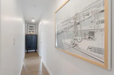 a hallway with a framed picture on a wall at Luxe Balboa House 5 Bedroom 5 Ensuite Bath Peninsula Ferry Close in Newport Beach