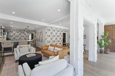 a living room with white furniture and a kitchen at Luxe Balboa House 5 Bedroom 5 Ensuite Bath Peninsula Ferry Close in Newport Beach