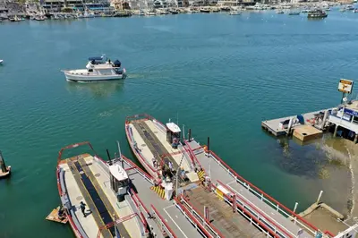 a boat is docked at a dock in the water at Luxe Balboa House 5 Bedroom 5 Ensuite Bath Peninsula Ferry Close in Newport Beach