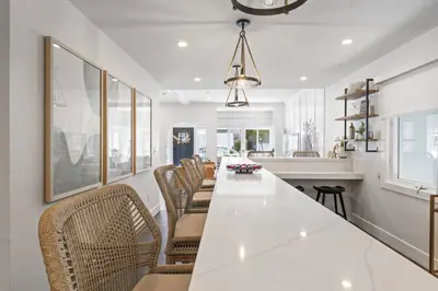 a kitchen with a long white table and chairs at Luxe Balboa House 5 Bedroom 5 Ensuite Bath Peninsula Ferry Close in Newport Beach