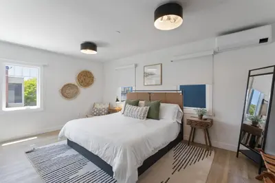 a bedroom with a large bed and a mirror at Luxe Balboa House 5 Bedroom 5 Ensuite Bath Peninsula Ferry Close in Newport Beach